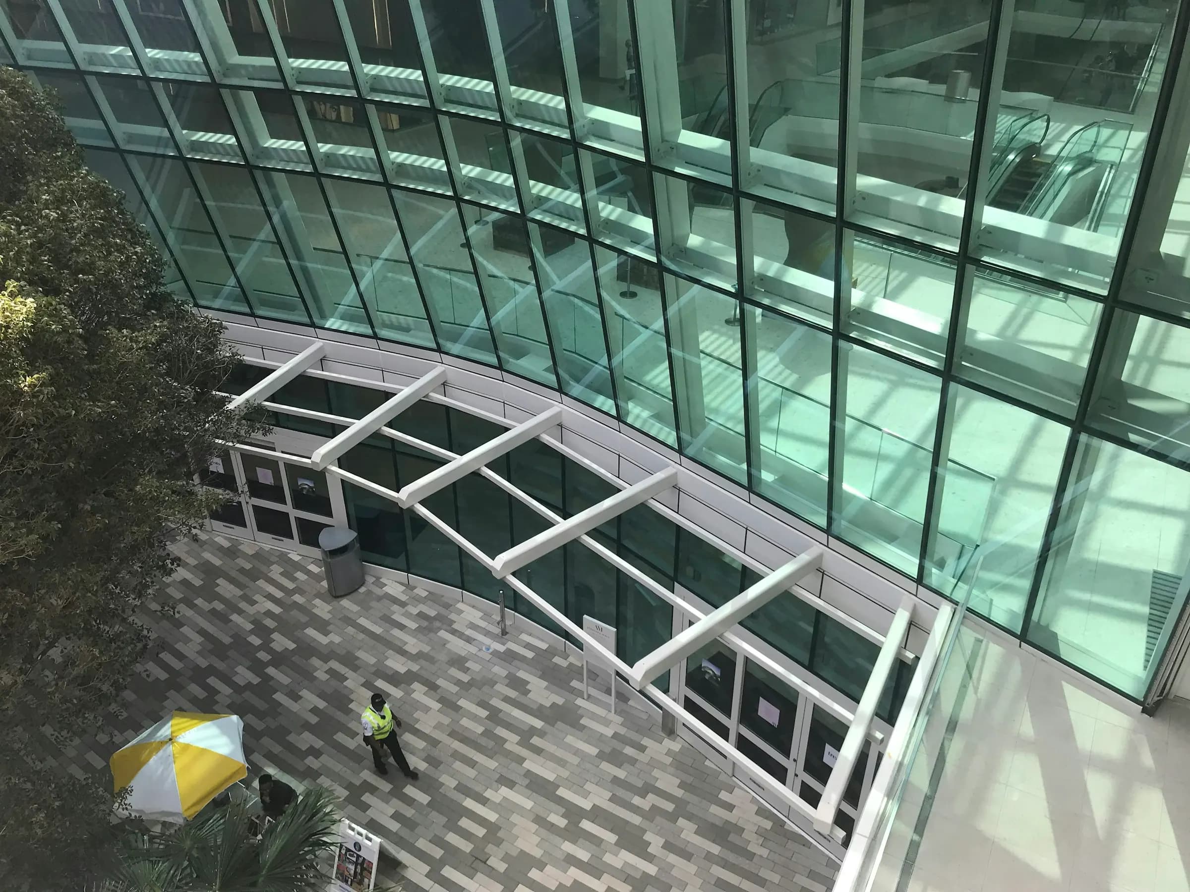 Bir alışveriş merkezinin kavisli camlı girişi, kuş bakışı
