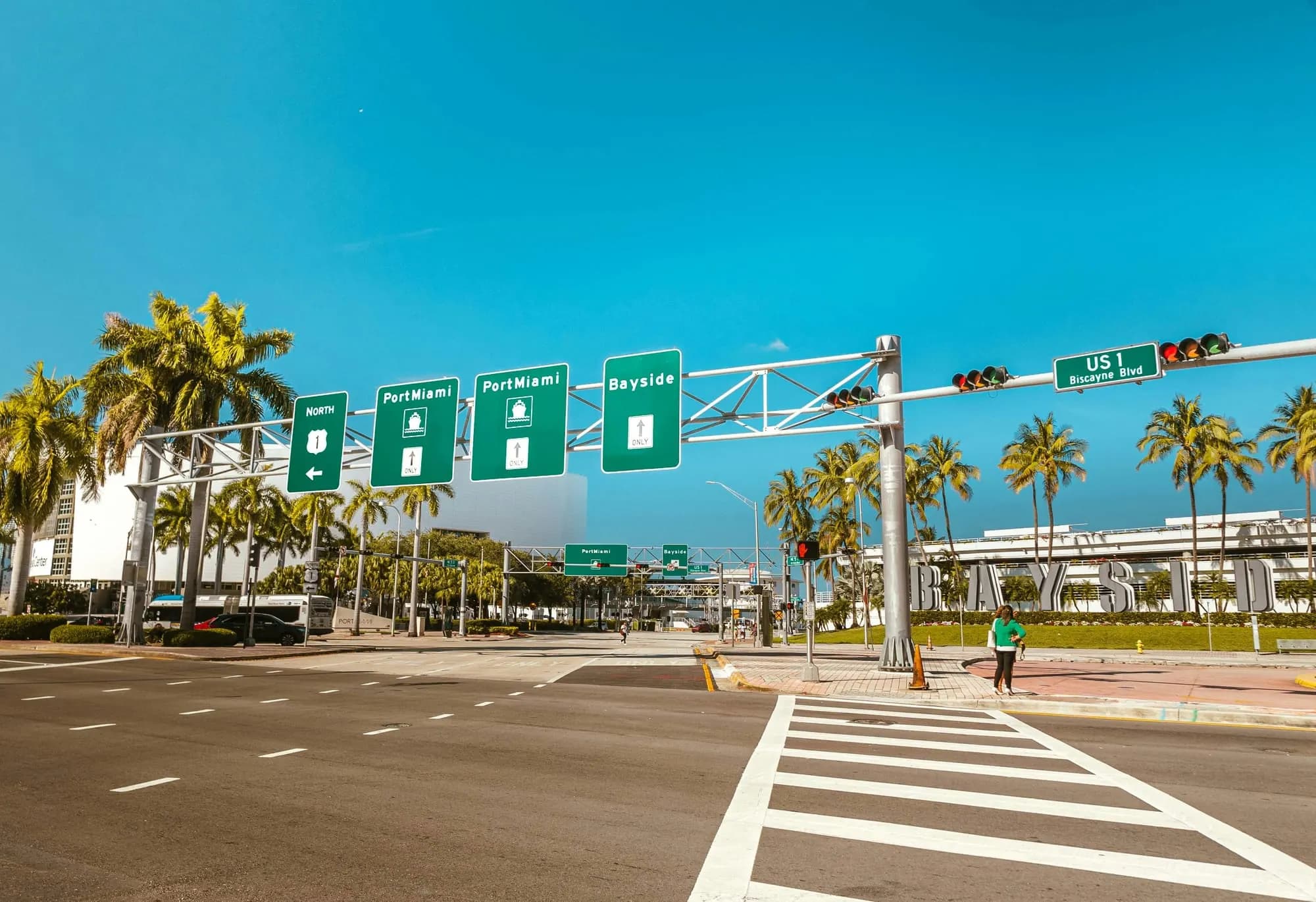 A wide boulevard hung with signs for PortMiami and Bayside